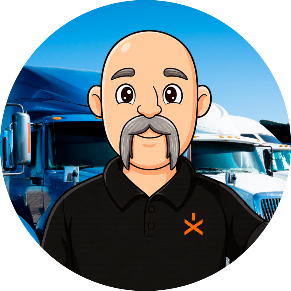Cartoon mascot of a smiling, bald man with a gray mustache wearing a black polo, standing in front of blue semi-trucks in a truck yard